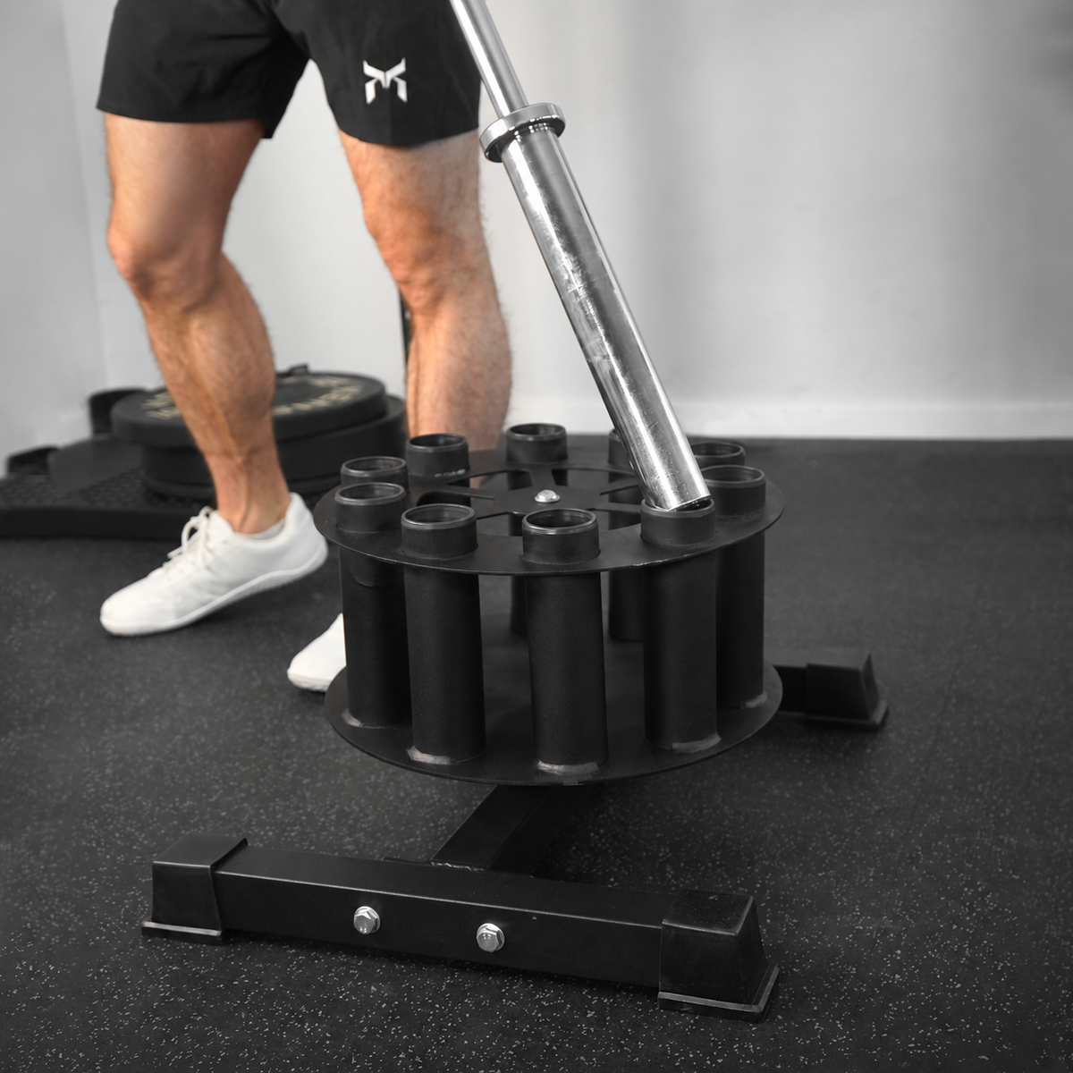 Black circular barbell storage holder with a silver barbell