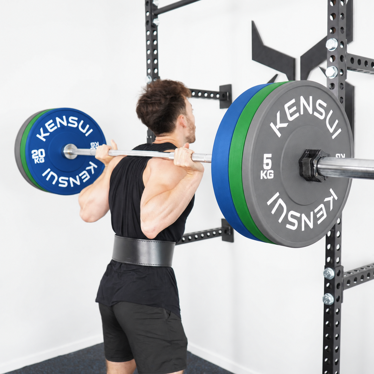 Barbell squat with grey outer plates, green middle plates, and blue inner Kensui bumper plates