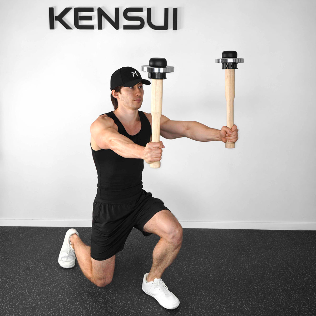 Athlete holding a pair of wooden EZ-CLUB PRO clubs with chrome plates in a half-kneeling stance.