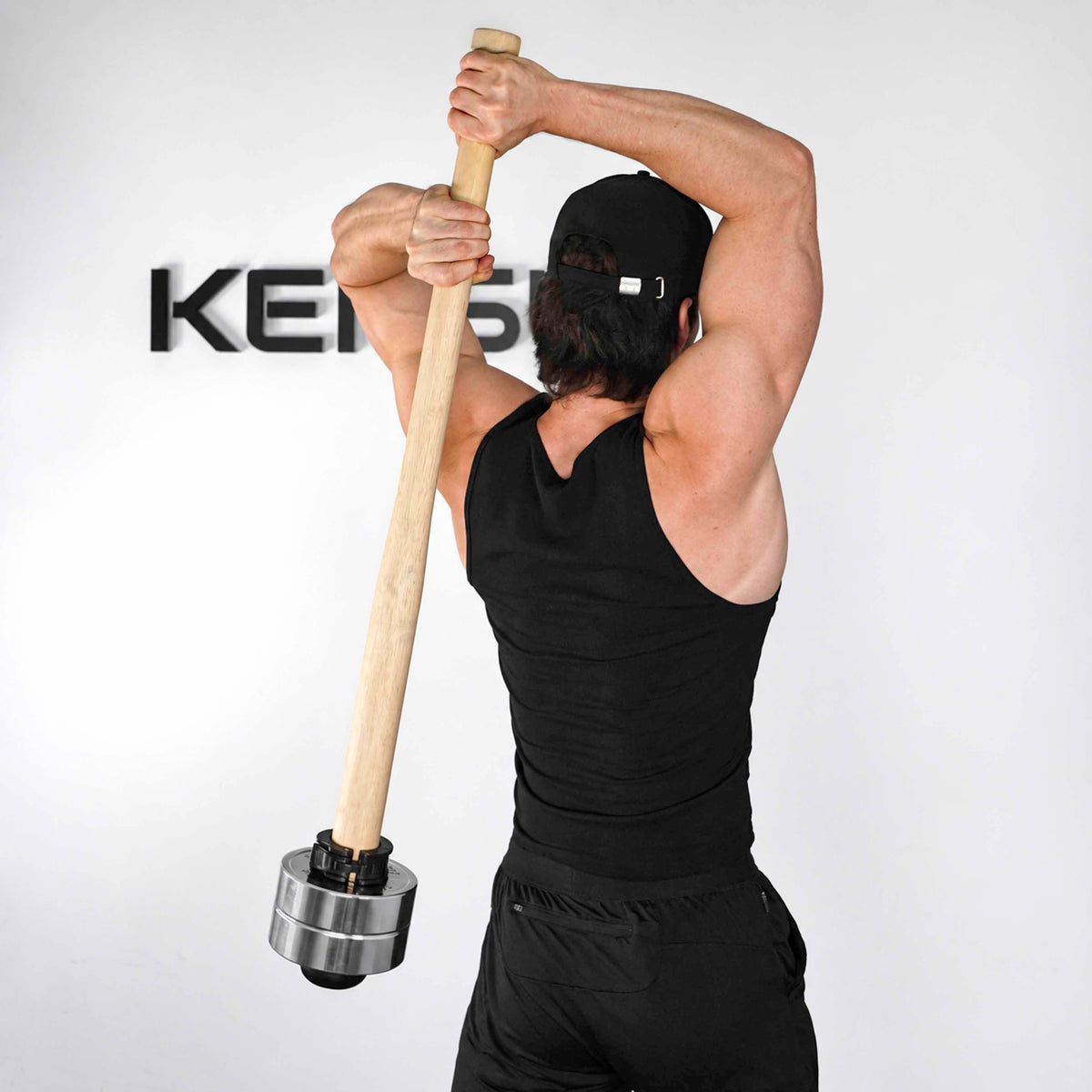 Rear view of an athlete holding the wooden EZ-MACE PRO behind the back with chrome weight plates.