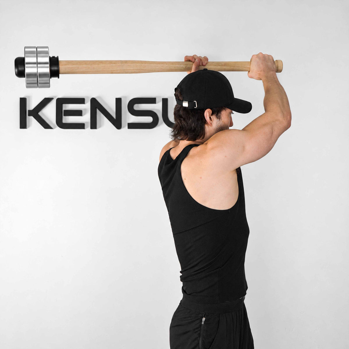 Athlete holding the wooden EZ-MACE PRO horizontally overhead with chrome weight plates.