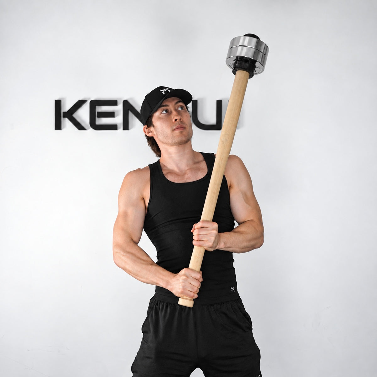 Athlete holding a wooden EZ-MACE PRO upright with chrome weight plates.