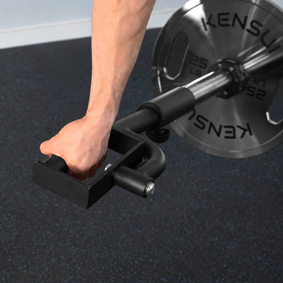 Close-up of a hand gripping the KENSUI rotating landmine handle during a row, showing the pivot and barbell connection.