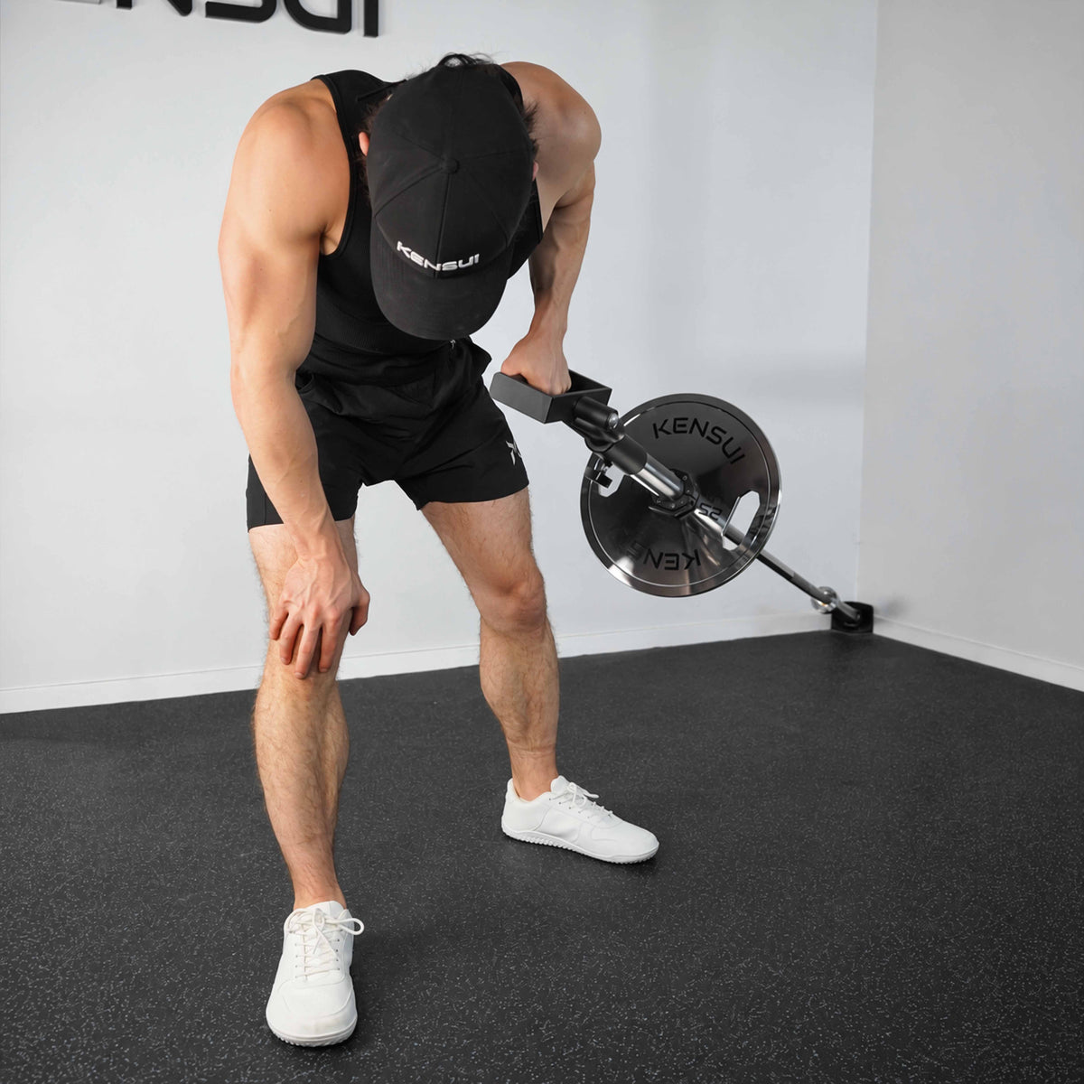 Athlete holding the KENSUI rotating landmine handle near the hip at the top of a single-arm row.