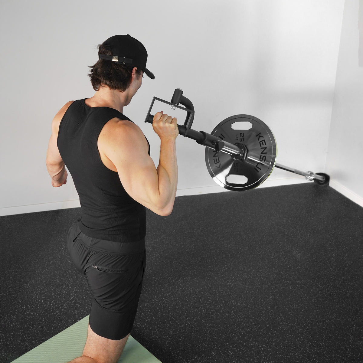 Athlete using the KENSUI rotating landmine attachment in a kneeling single-arm press at shoulder height.