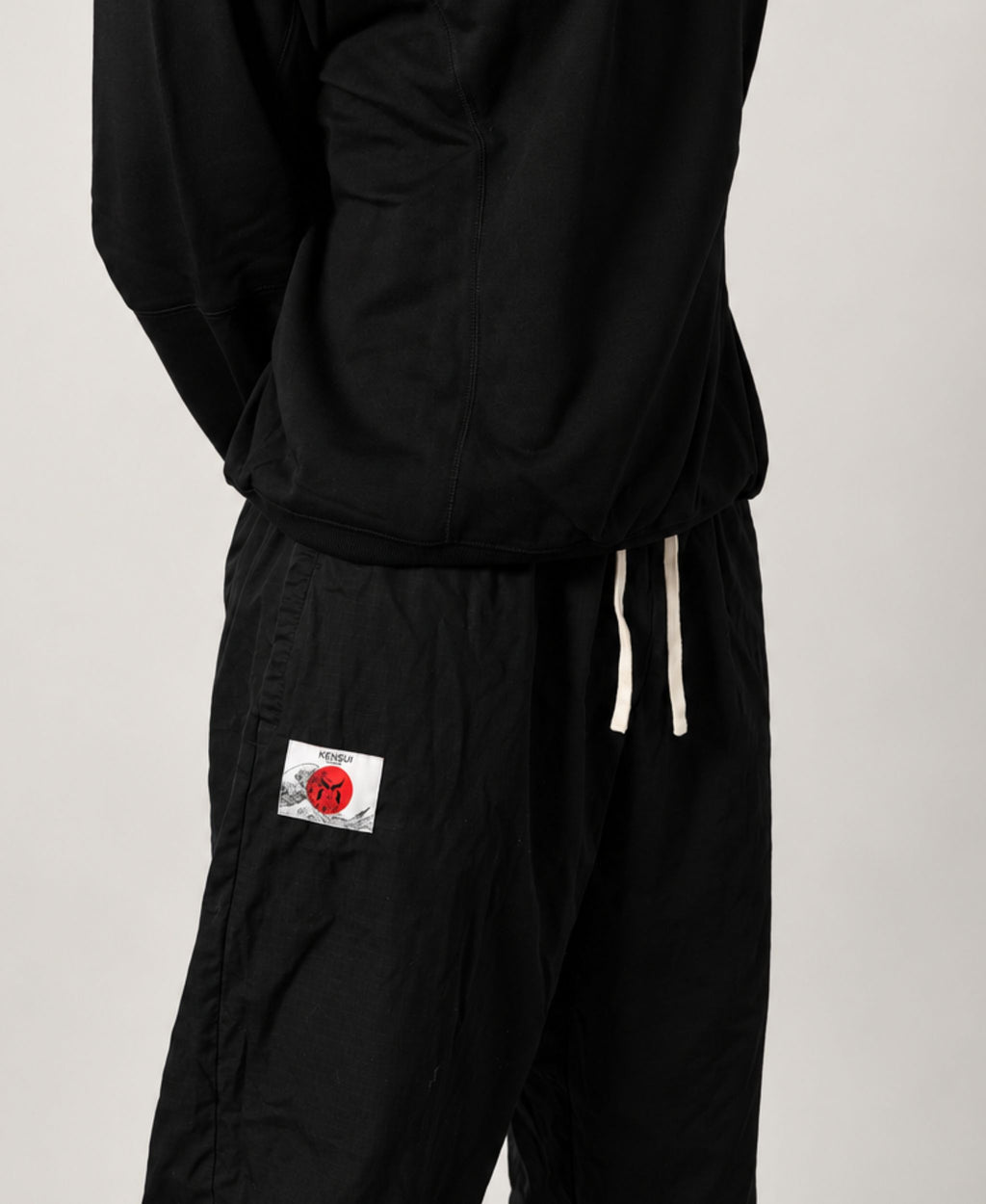 Black cotton pant with a white and red Kensui patch below the waistband.