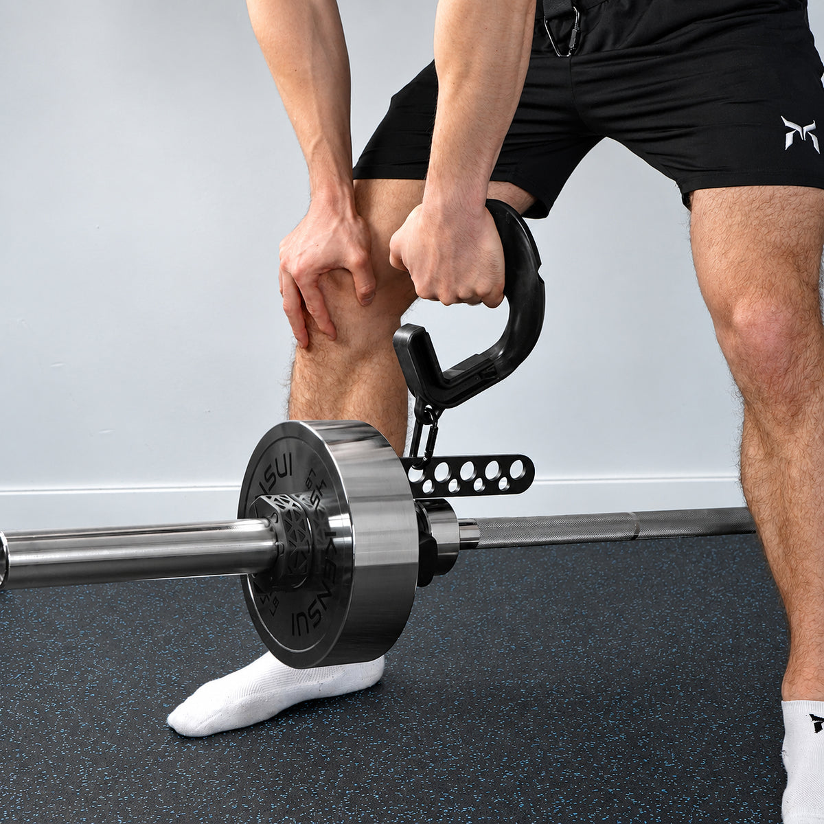 Close-up of an athlete rowing with a carabiner-connected handle and landmine attachment