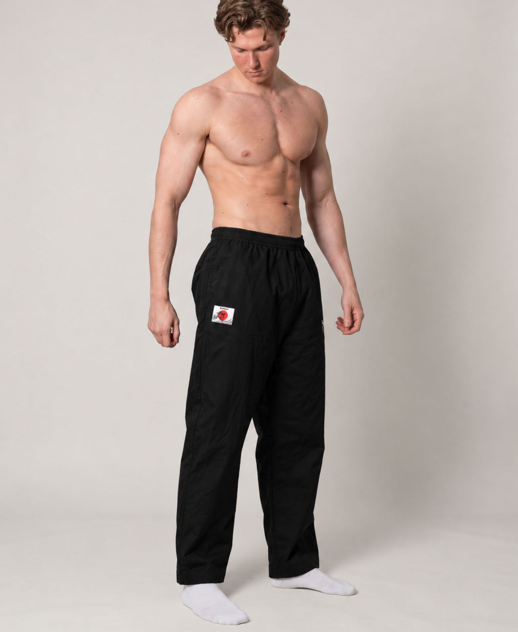Black straight-leg pant modeled from the front, showing the relaxed fit and open hems.