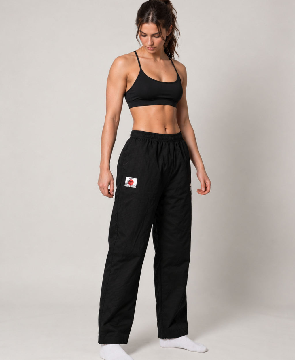 Black straight-leg pant worn by a woman, showing the relaxed fit and open hems.