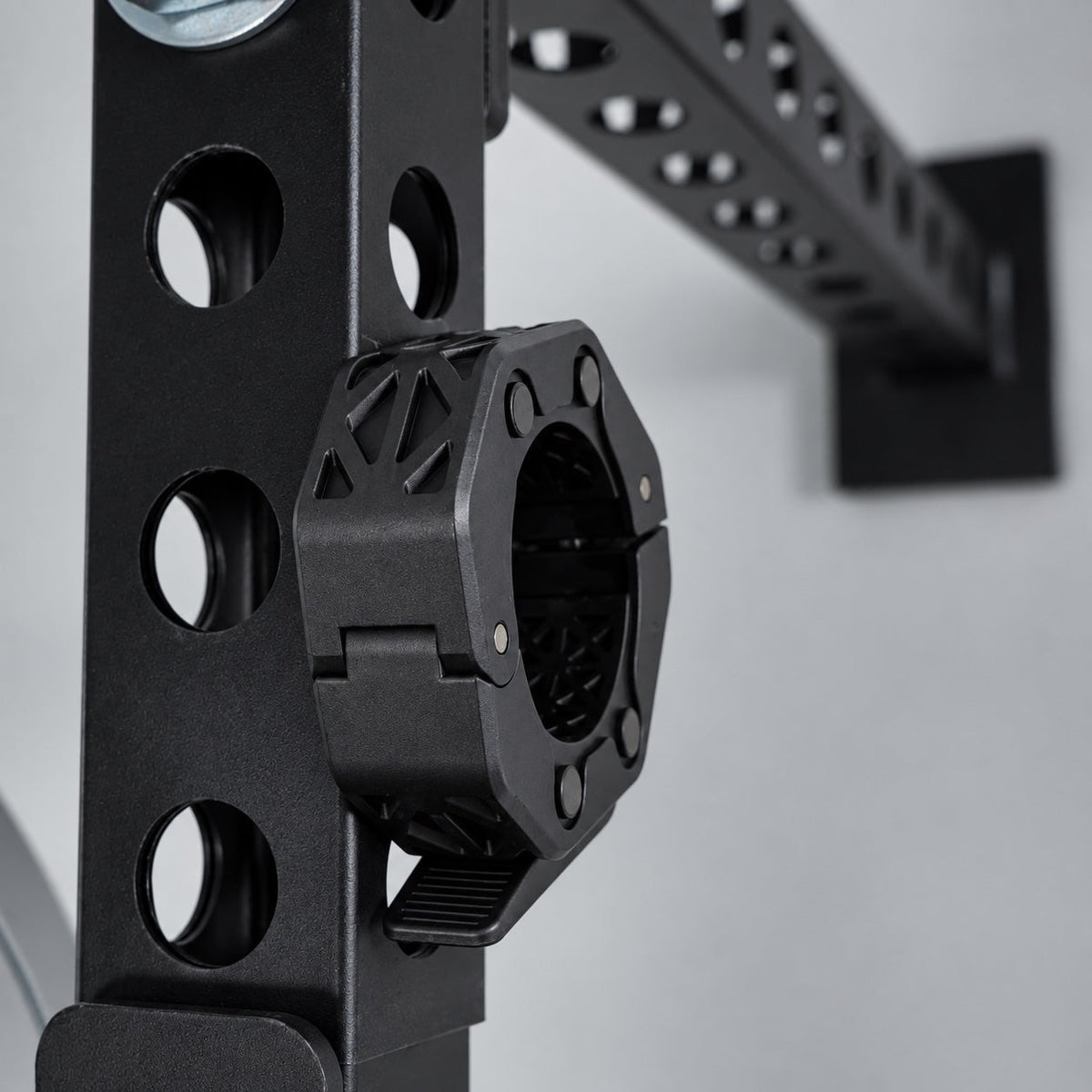 Kensui magnetic barbell collar attached to a steel power rack for storage