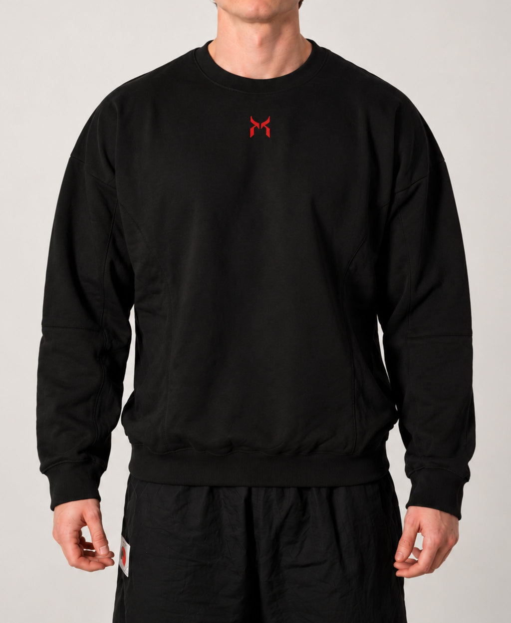 Nanakoribi Crew in black with red print, front view showing the relaxed drop-shoulder fit.