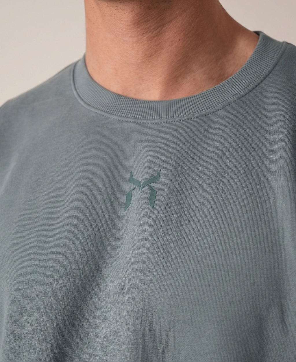 Nanakoribi Crew in blue, close-up of the chest logo and ribbed neckline.
