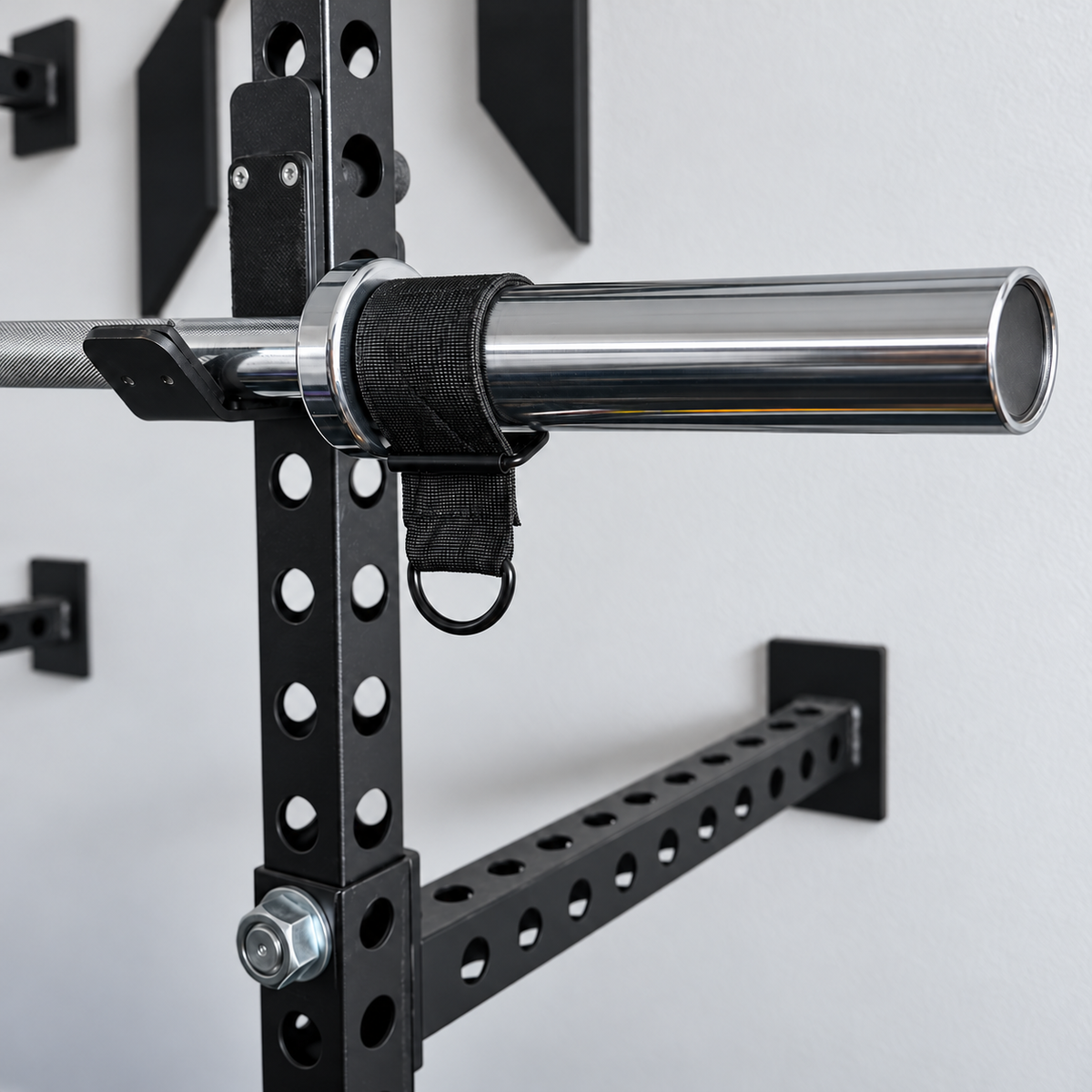 Rubber lined strap fitted around an Olympic barbell sleeve with the D-ring hanging below