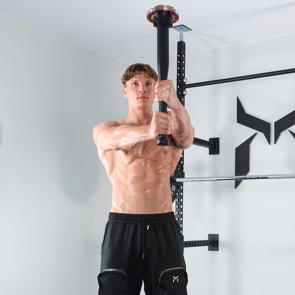 Athlete holding the black steel EZ-CLUB MAX upright with weight plates
