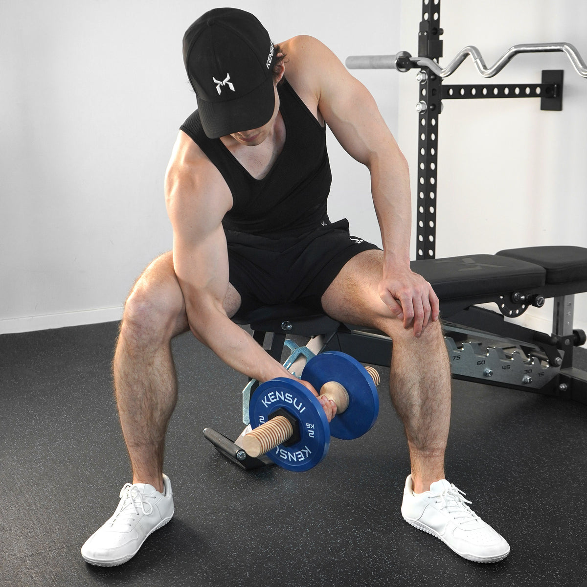 Seated curl with a Timber wooden dumbbell loaded with blue weight plates