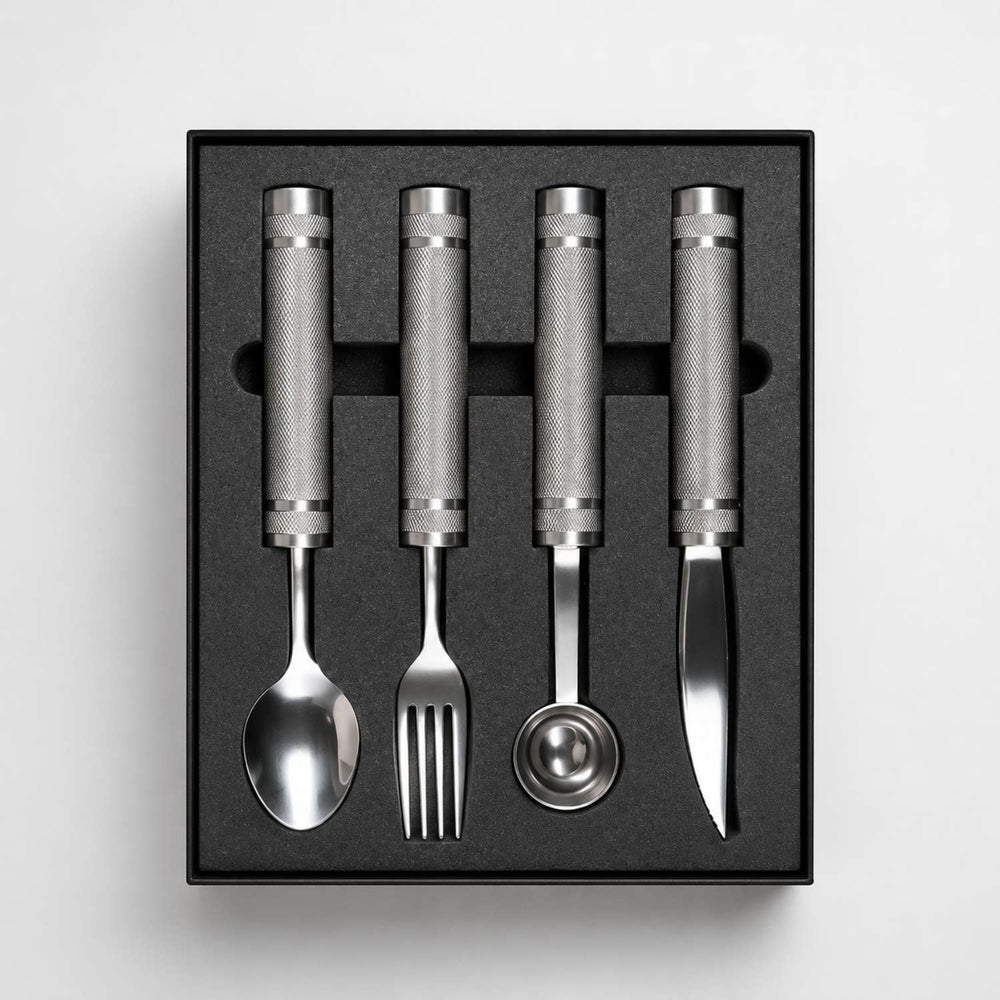 Four weighted utensils arranged in their presentation box