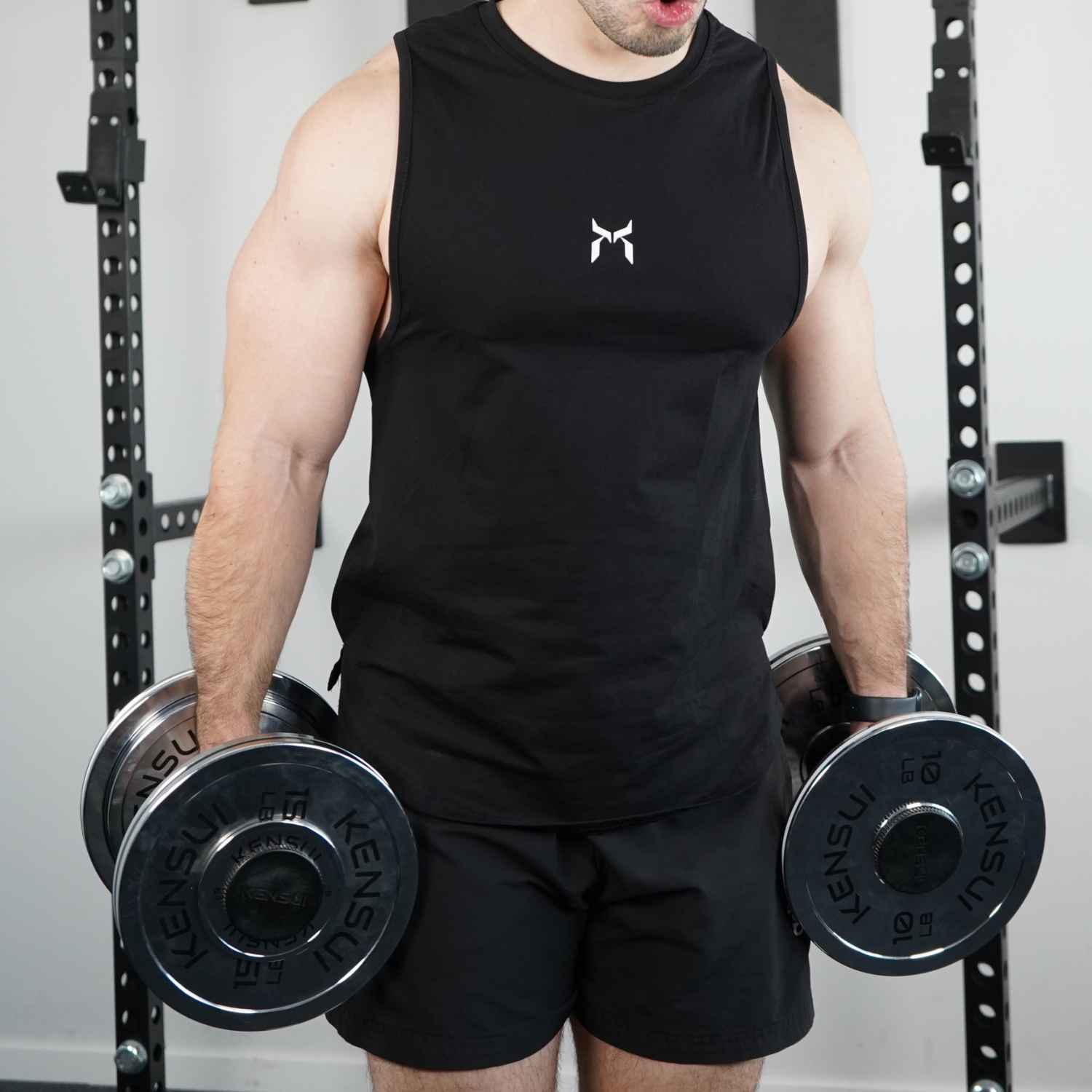 
Person standing with a dumbbell in each hand.