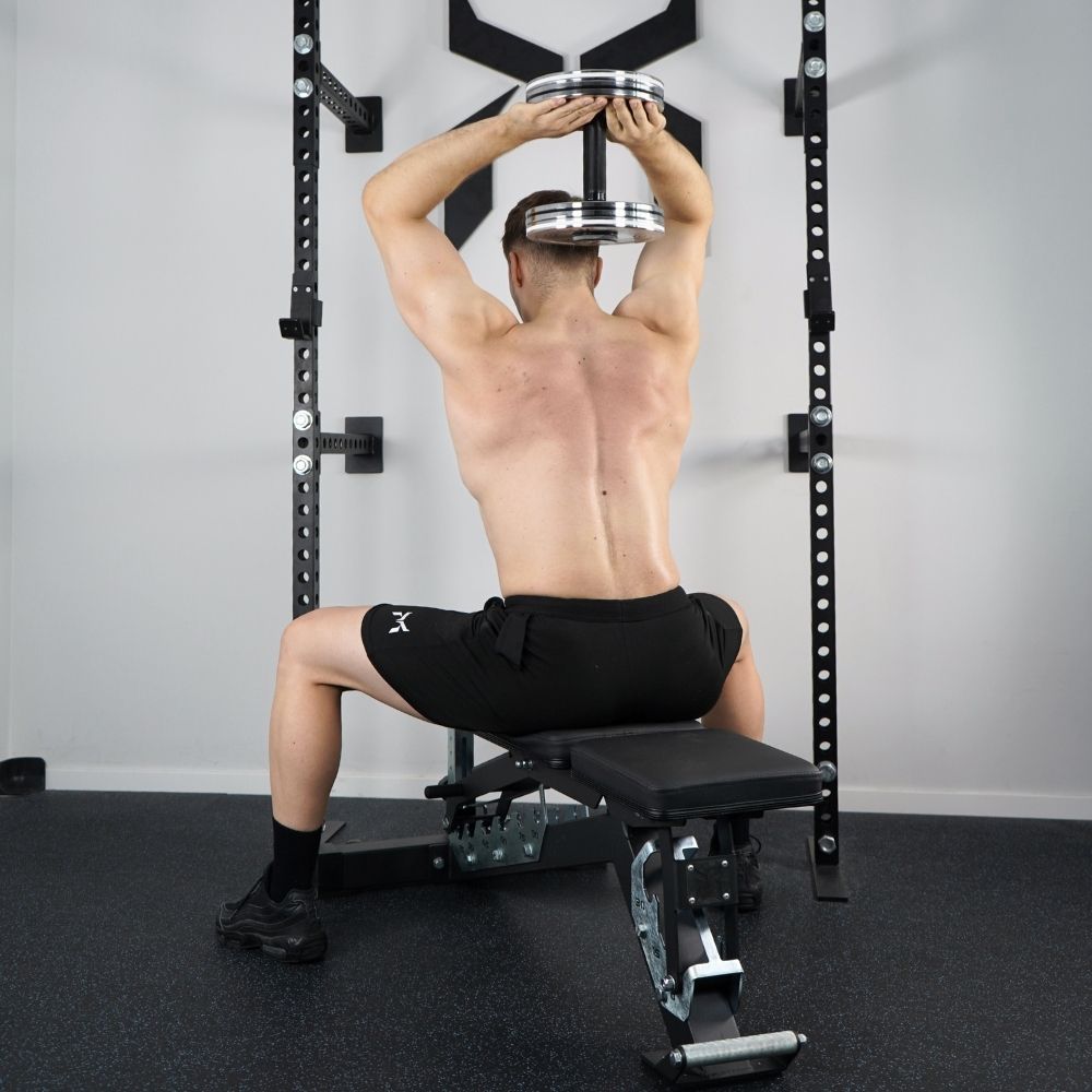 
Person performing an overhead triceps extension with a dumbbell.