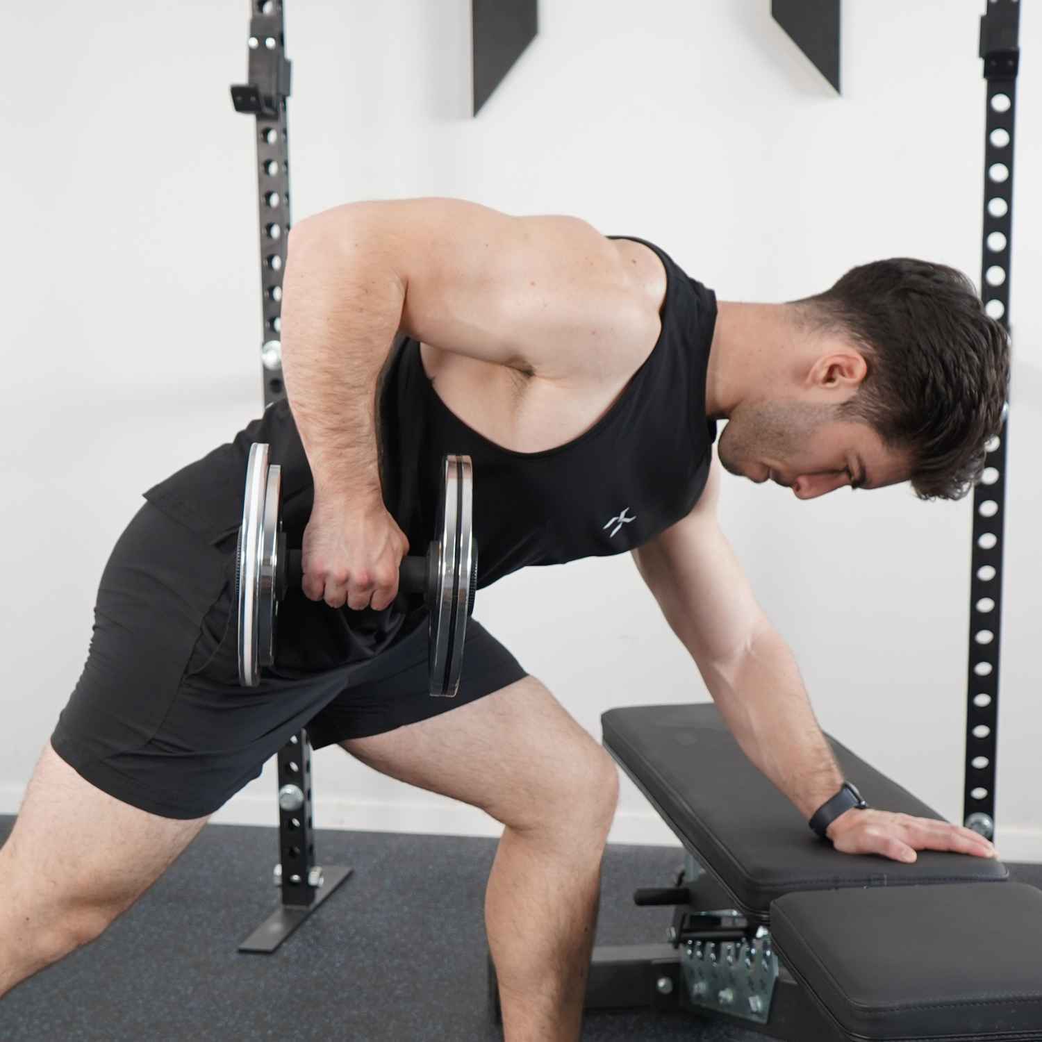 
Person performing a bench-supported single-arm dumbbell row.