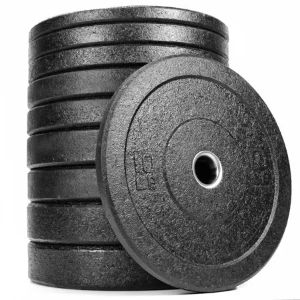 Stack of black textured bumper plates with one plate standing in front.
