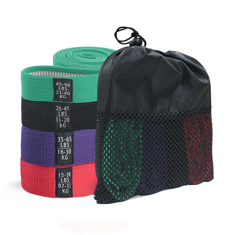 Rolled fabric resistance bands in four colors beside a mesh carrying pouch.