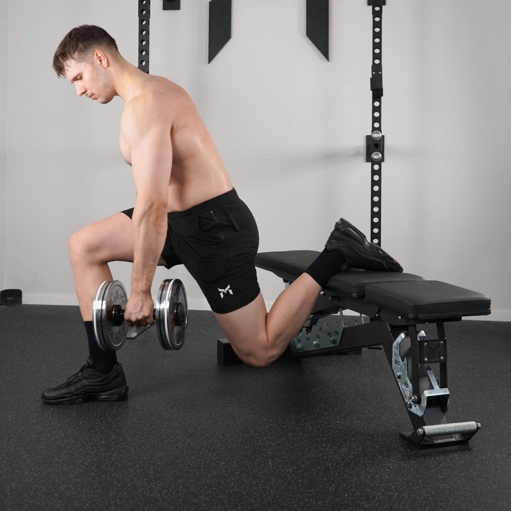 Person performing a rear-foot-elevated split squat while holding dumbbells.