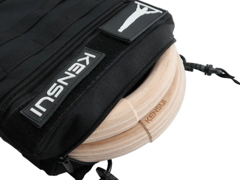 Wooden gymnastic rings packed into a black Kensui carrying bag.