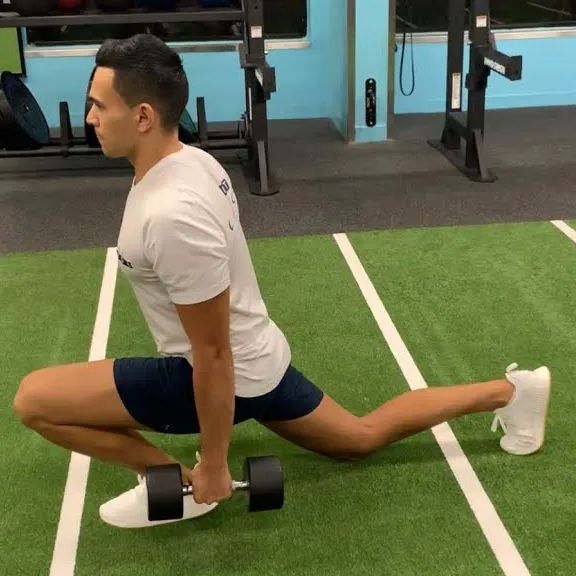 Person doing a deep split squat while holding dumbbells.