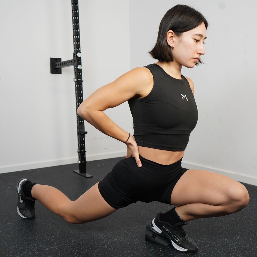 Person demonstrating a deep bodyweight split squat.